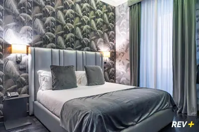 a bedroom with a bed with a floral wallpaper at Via Veneto Suites in Rome