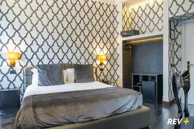 a bedroom with a bed and a wall at Via Veneto Suites in Rome