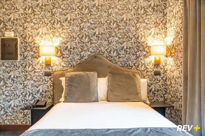 a bedroom with a bed with two lamps on the wall at Via Veneto Suites in Rome