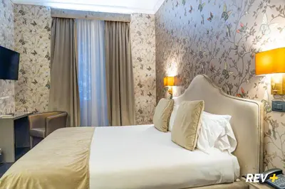 a bedroom with a bed and a desk in a room at Via Veneto Suites in Rome