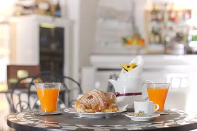a table with a breakfast of croissants and orange juice at Villa Pirandello in Rome