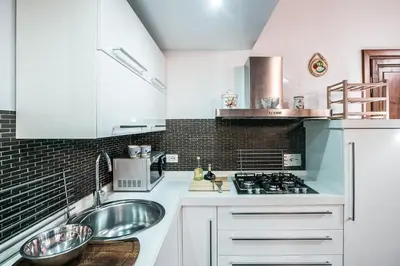 a white kitchen with a sink and a stove at In Front Of Coliseum in Rome