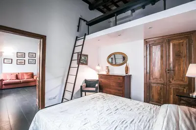 a bedroom with a bed and a ladder and a mirror at In Front Of Coliseum in Rome