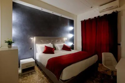 a bedroom with a large bed with red curtains at Rome By Suite Vatican in Rome