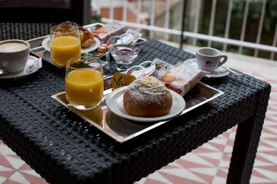 a table with a tray of breakfast food and orange juice at Rome By Suite Vatican in Rome