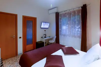 a hotel room with a bed and a television at Rome By Suite Vatican in Rome