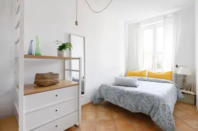 a white bedroom with a bed and a dresser at Panoramic Castle Apt Trastevere in Rome