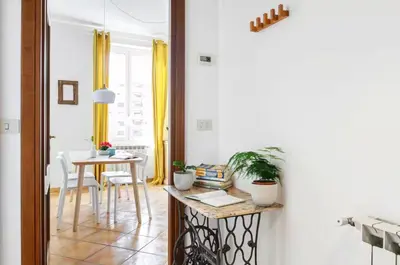 a kitchen with a table and a dining room with yellow curtains at Panoramic Castle Apt Trastevere in Rome