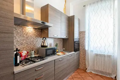 a kitchen with wooden cabinets and a stove top oven at Veneto Prestige Apartment in Rome