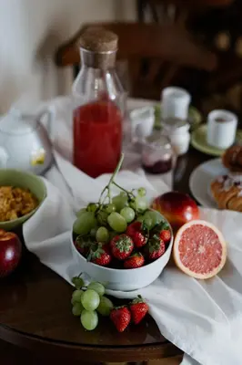 a table topped with a bowl of strawberries and grapes at La Girandola Bed & Breakfast in Rome