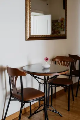 a table with chairs and a vase with a flower on it at La Girandola Bed & Breakfast in Rome