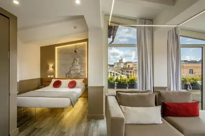 a bedroom with a bed and a couch and a window at Hotel Regno in Rome