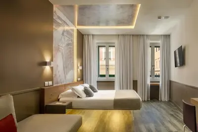 a hotel room with two beds and a couch at Hotel Regno in Rome