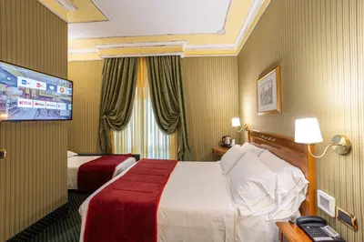 a hotel room with two beds and a flat screen tv at Hotel Manfredi Suite In Rome in Rome