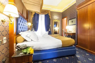a hotel room with a bed and a telephone at Hotel Manfredi Suite In Rome in Rome