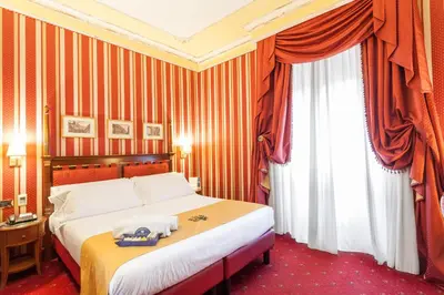 a hotel room with a bed and a window at Hotel Manfredi Suite In Rome in Rome