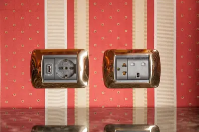two electrical outlets on a red and white wall at Hotel Manfredi Suite In Rome in Rome