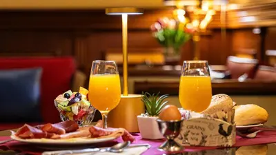 a table with two glasses of orange juice and bacon at Hotel Manfredi Suite In Rome in Rome