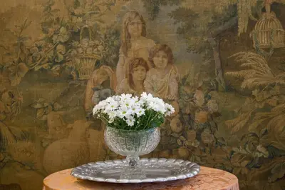 a vase with white flowers on a table with a painting at Suite Oriani in Rome
