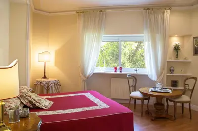 a bedroom with a bed and a table and a window at Suite Oriani in Rome
