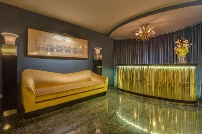 a lobby with a yellow couch and a chandelier at Otivm Hotel in Rome