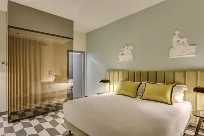 a bedroom with a large white bed with yellow pillows at Otivm Hotel in Rome