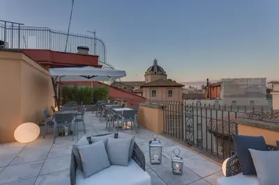 a balcony with tables and chairs on a building at Otivm Hotel in Rome