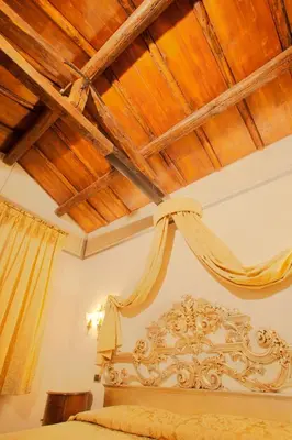 a bedroom with a bed with a wooden ceiling at Hotel Aventino in Rome