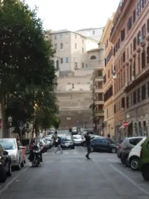 a city street with cars and people walking on the street at Sylvia Stylish Vatican Apartment in Rome