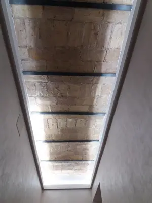 a stairwell with a wooden ceiling in a house at Sylvia Stylish Vatican Apartment in Rome