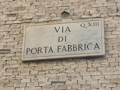 a sign on the side of a brick wall at La Fabbrica di San Pietro B&B in Rome