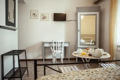 a living room with a table and a mirror at La Fabbrica di San Pietro B&B in Rome