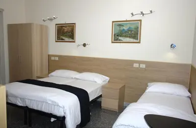 a hotel room with two beds and two pictures on the wall at In vacanza da Sara in Rome