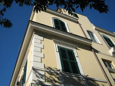 a tall building with green shutters on it at La Rotella Nel Sacco in Rome