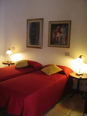 a bedroom with two red beds and two lamps at La Rotella Nel Sacco in Rome