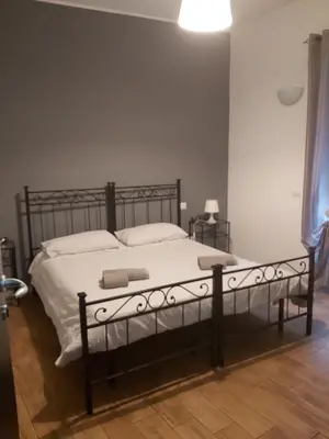 a bedroom with a bed with white sheets and pillows at Marco E Laura Affittacamere al Vaticano in Rome