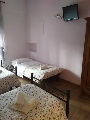 a room with two beds and a tv on the wall at Marco E Laura Affittacamere al Vaticano in Rome
