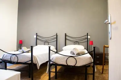 two beds in a room with white sheets at Marco E Laura Affittacamere al Vaticano in Rome