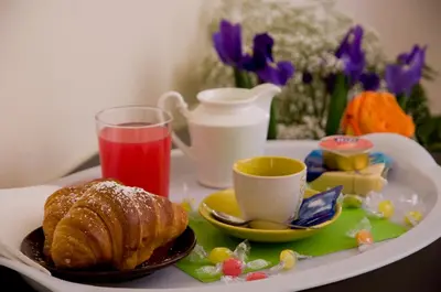 a tray with a breakfast plate with a croissant and a drink at Titina B&B in Rome