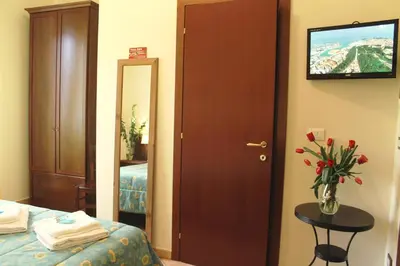 a hotel room with a bed and a vase of flowers at Titina B&B in Rome