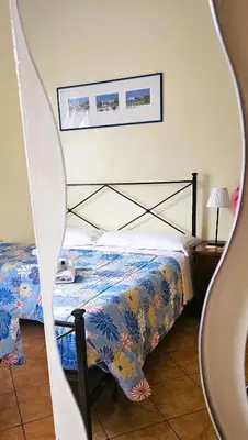 a bedroom with a bed with a blue comforter at Titina B&B in Rome