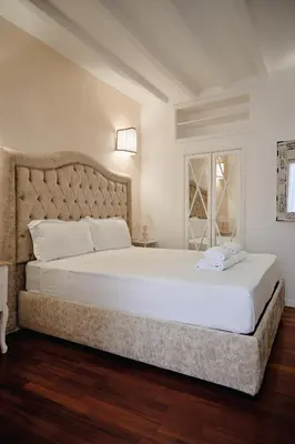 a bedroom with a large white bed with a large headboard at Cozy Studio Parlamento in Rome