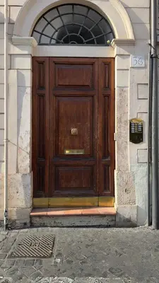 a large wooden door in a building with an arch at Cozy Studio Parlamento in Rome