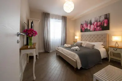 a bedroom with a bed and a vase of pink flowers at Dream Holiday Home in Rome