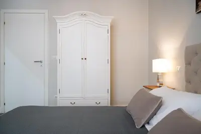 a bedroom with a bed and a large white cabinet at Dream Holiday Home in Rome