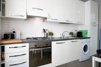 a kitchen with white cabinets and a stove top oven at Dream Holiday Home in Rome