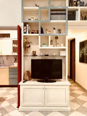 a tv on a white entertainment center in a living room at Delicious House in Rome