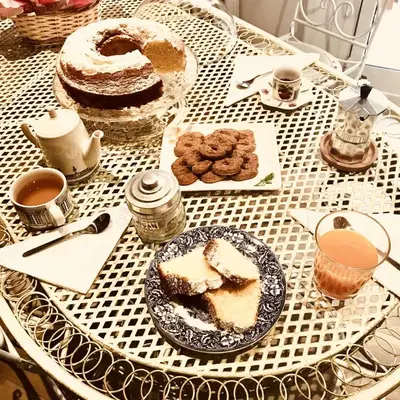 a table with a plate of cake and cookies on it at Delicious House in Rome