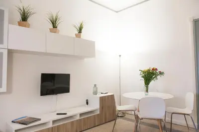 a white living room with a white table and chairs at Miani House in Rome