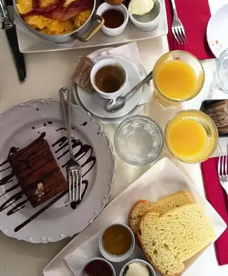a table with a plate of chocolate cake and bread at iRooms - Spanish Steps in Rome